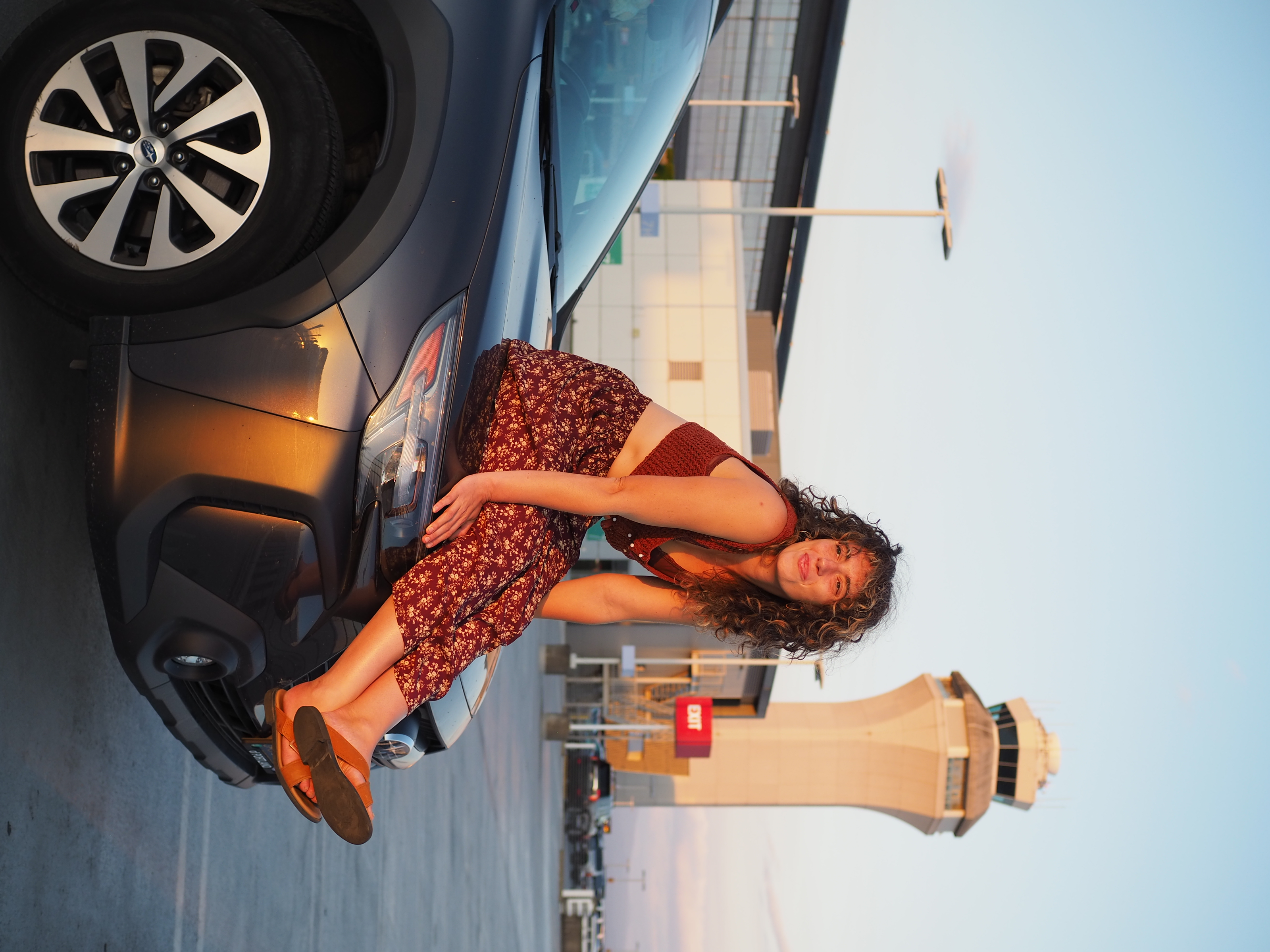 Lucy posing on top of a car